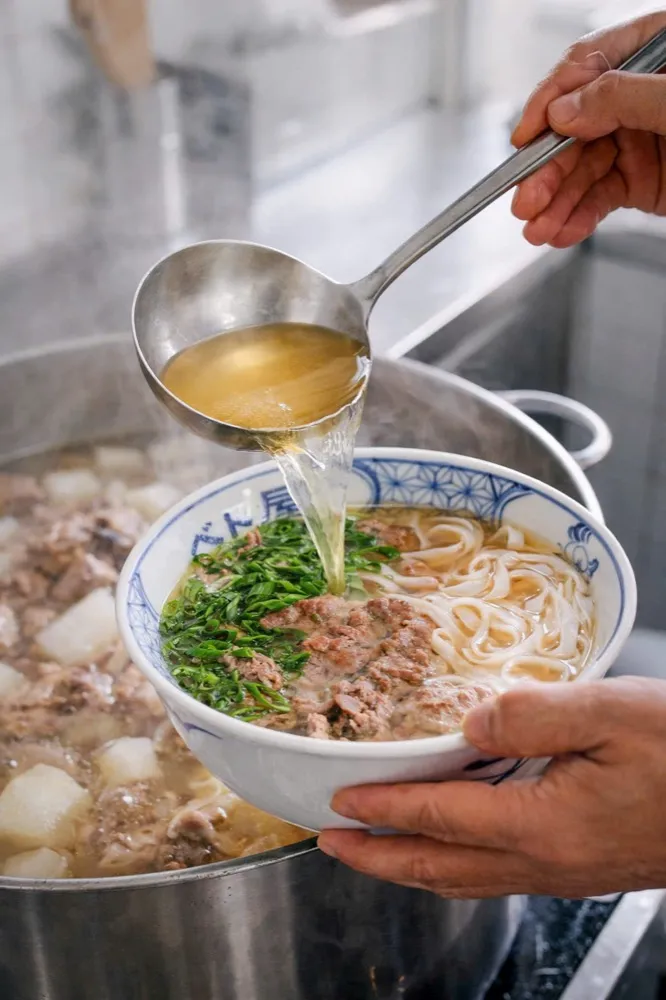寸胴からフォーの器にスープを注ぐ様子