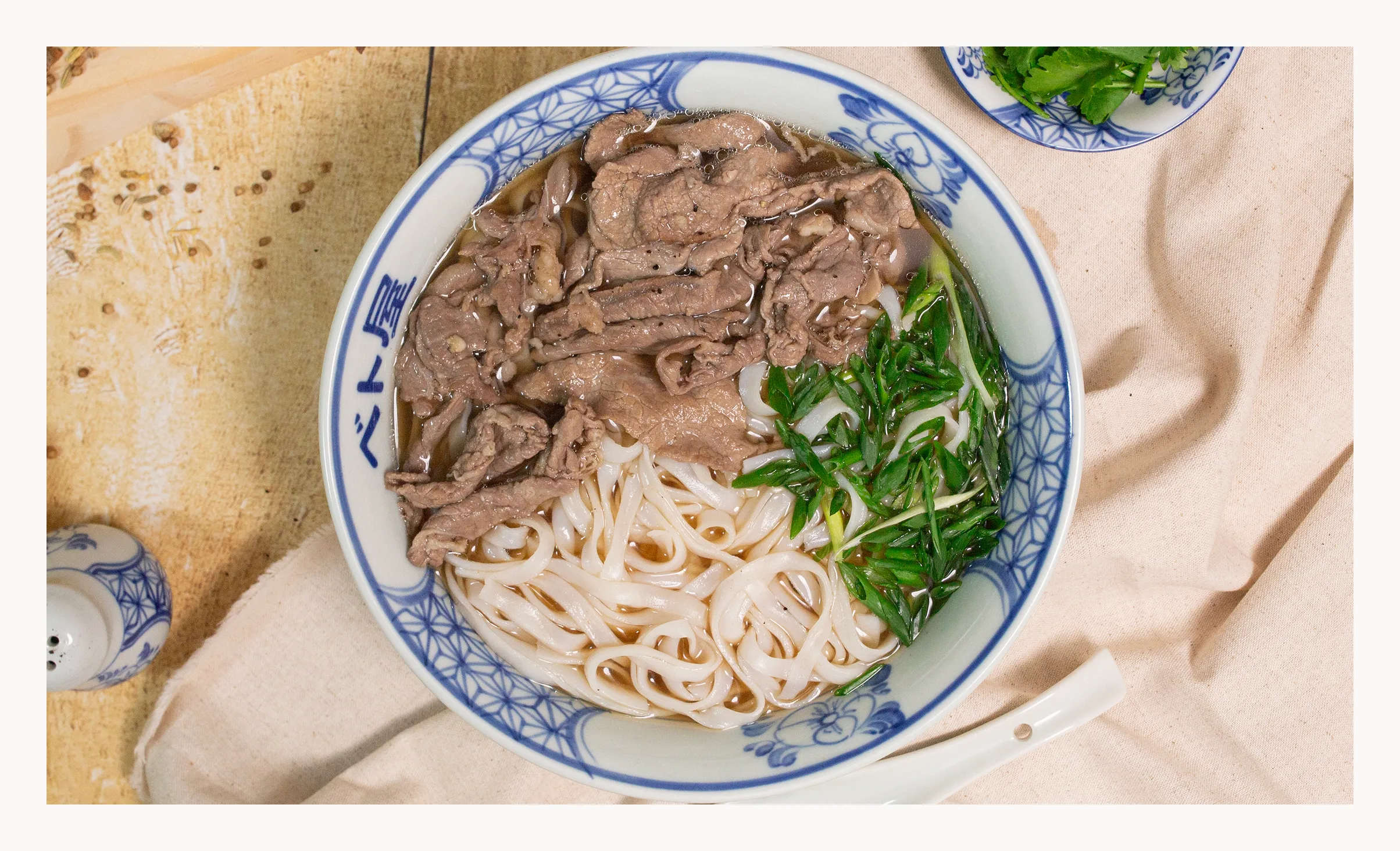 BETOYAの牛フォーを真上から見た一杯とハーブの皿