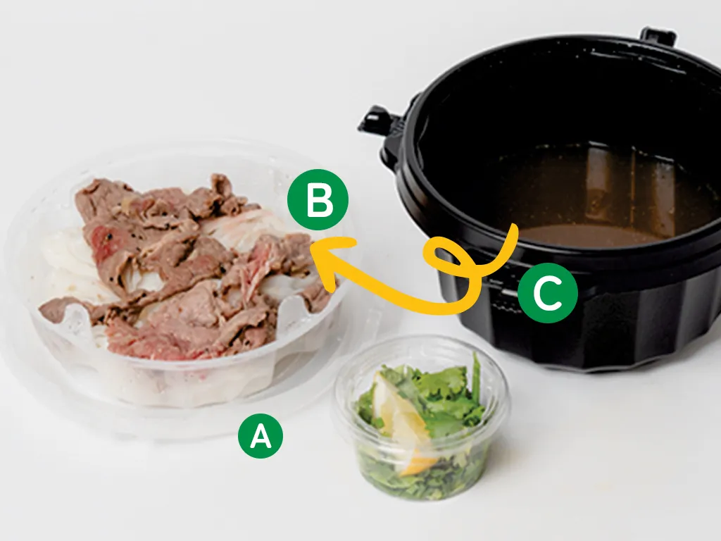裏返した外蓋（A）の上に、麺と肉が乗った中蓋（B）を置き、スープの容器（C）を空ける様子。